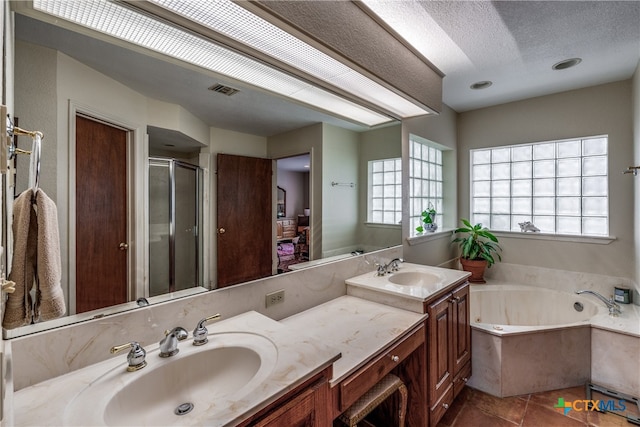 bathroom featuring tile patterned flooring, vanity, separate shower and tub, and a textured ceiling