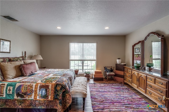 bedroom featuring hardwood / wood-style flooring and a textured ceiling