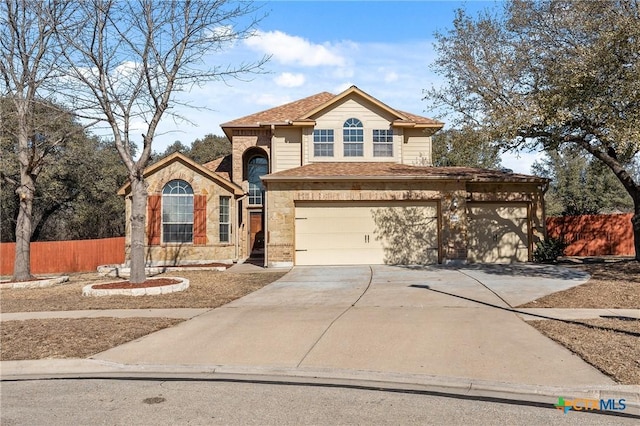 traditional-style home featuring concrete driveway, roof with shingles, stone siding, and fence