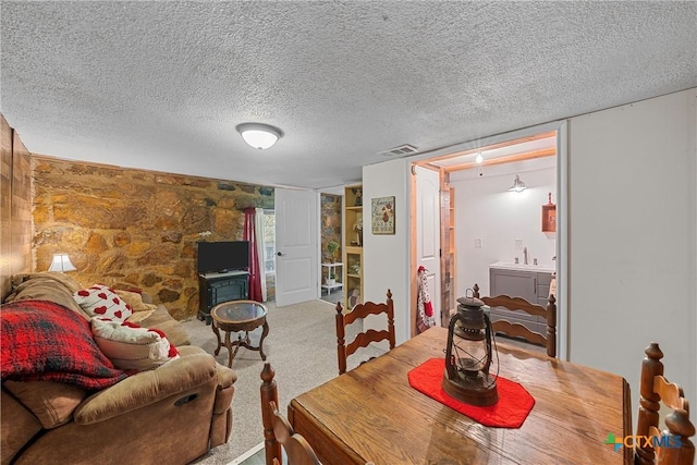 carpeted dining room featuring sink and a textured ceiling