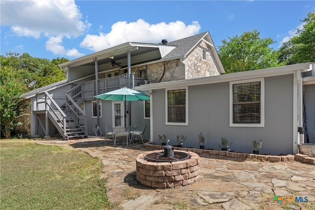 back of house featuring a balcony, an outdoor fire pit, a patio area, and ceiling fan