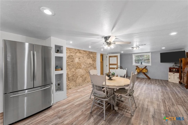 dining space with built in shelves, light hardwood / wood-style floors, and ceiling fan