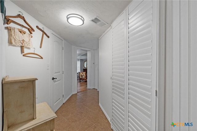 hallway with a textured ceiling