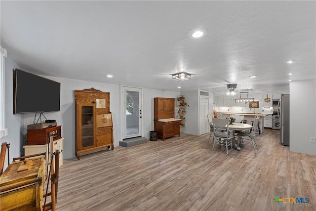 living room featuring ceiling fan and light hardwood / wood-style flooring