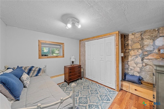 living room with a textured ceiling and light hardwood / wood-style flooring