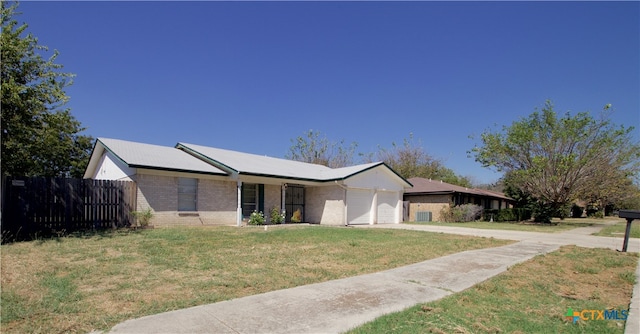 ranch-style house with a garage and a front lawn