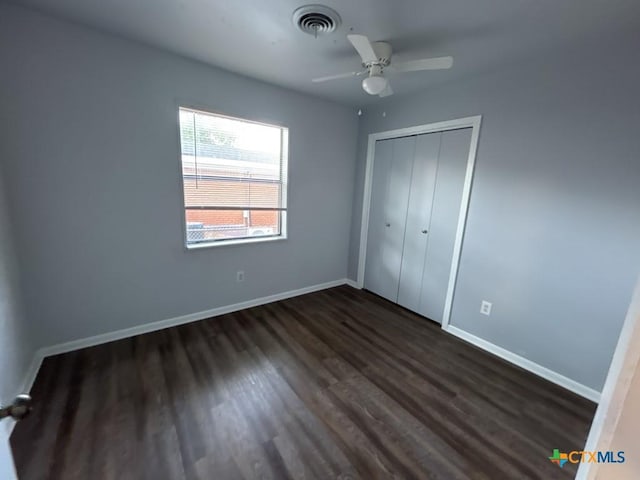 unfurnished bedroom featuring ceiling fan, a closet, and dark hardwood / wood-style floors