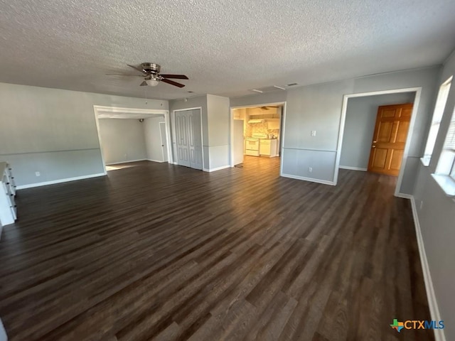 unfurnished living room featuring ceiling fan, dark hardwood / wood-style flooring, and a textured ceiling