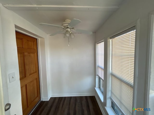 empty room with ceiling fan and dark wood-type flooring