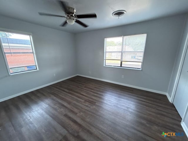 spare room featuring ceiling fan and dark wood-type flooring