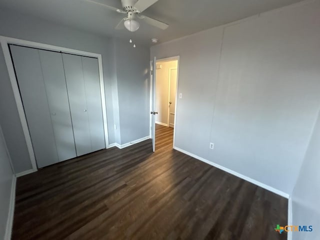 unfurnished bedroom with ceiling fan, a closet, and dark hardwood / wood-style floors