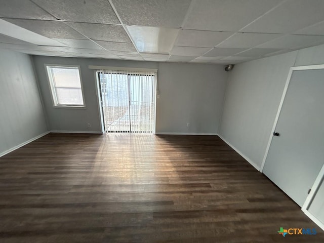 unfurnished room with a paneled ceiling and dark wood-type flooring