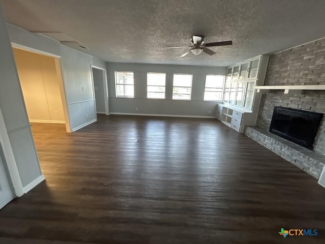 unfurnished living room with a fireplace, a textured ceiling, dark hardwood / wood-style flooring, and ceiling fan