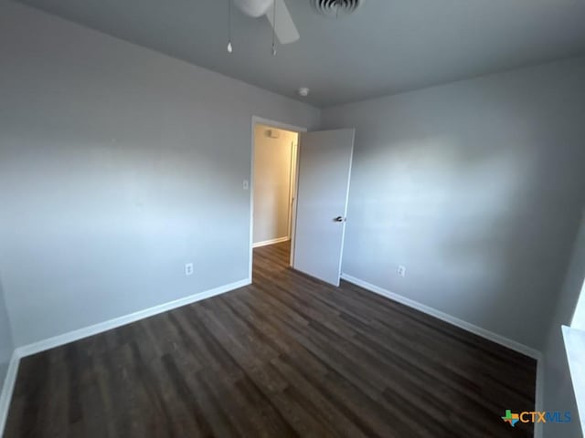 unfurnished bedroom featuring ceiling fan and dark hardwood / wood-style flooring