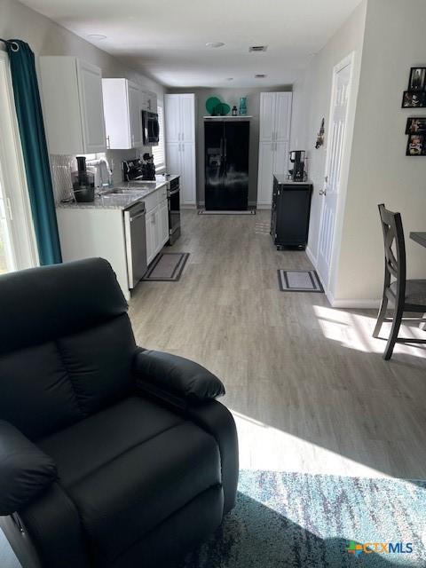 living room featuring sink and light hardwood / wood-style floors