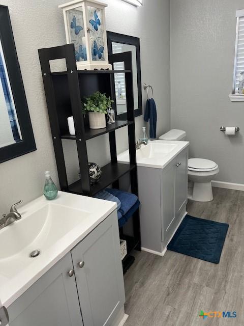 bathroom with hardwood / wood-style flooring, vanity, and toilet