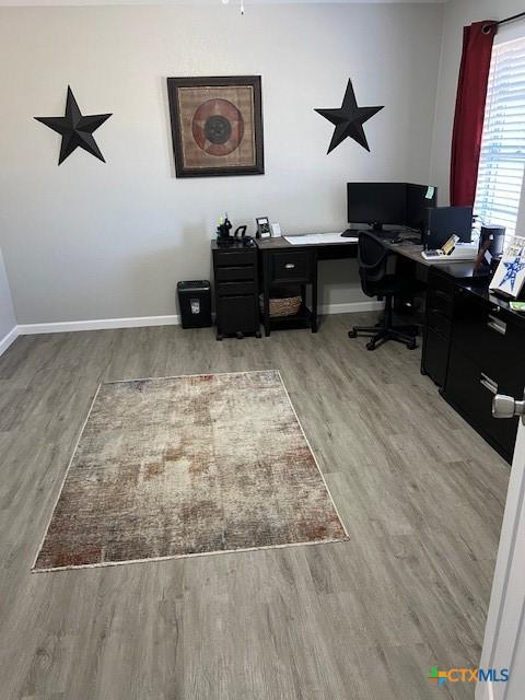 home office with light hardwood / wood-style flooring