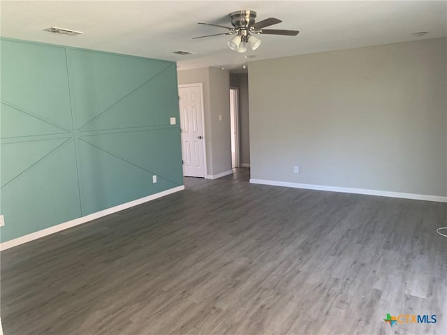 empty room featuring ceiling fan and dark hardwood / wood-style flooring