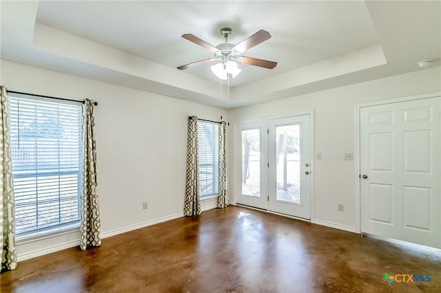 foyer with ceiling fan and a raised ceiling