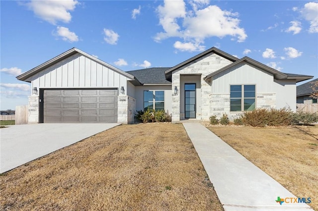 view of front of property with a garage, stone siding, board and batten siding, and concrete driveway