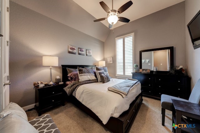 carpeted bedroom with ceiling fan and vaulted ceiling