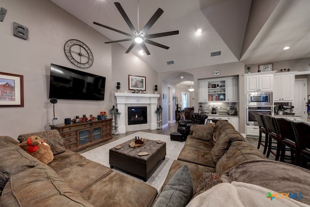 living room featuring high vaulted ceiling, ceiling fan, and light hardwood / wood-style flooring