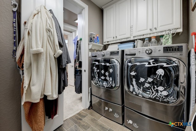 washroom with cabinets and washer and dryer