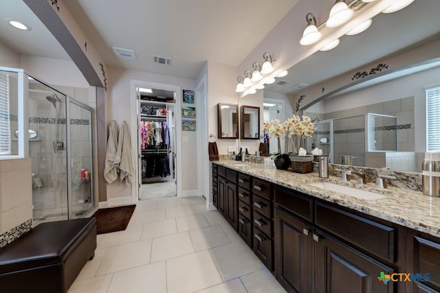 bathroom featuring vanity, tile patterned flooring, and a shower with shower door