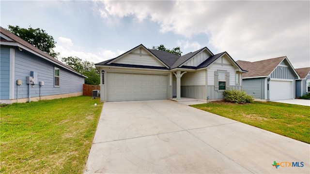 1519 Merritt St, Temple, TX 76504 - view of front facade featuring board and batten siding, a front lawn, a garage, and concrete driveway