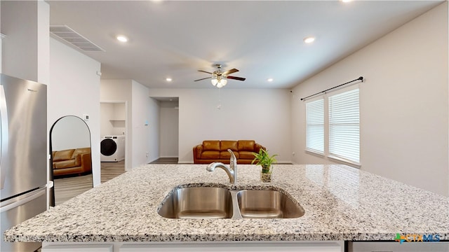 1519 Merritt St, Temple, TX 76504 - kitchen featuring freestanding refrigerator, washer / dryer, a sink, ceiling fan, and wood finished floors