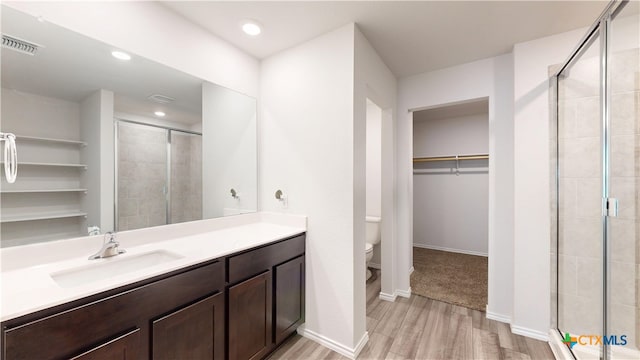 1519 Merritt St, Temple, TX 76504 - full bath featuring wood finished floors, a stall shower, a spacious closet, toilet, and recessed lighting