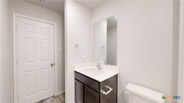 1519 Merritt St, Temple, TX 76504 - bathroom with toilet, vanity, and wood finished floors