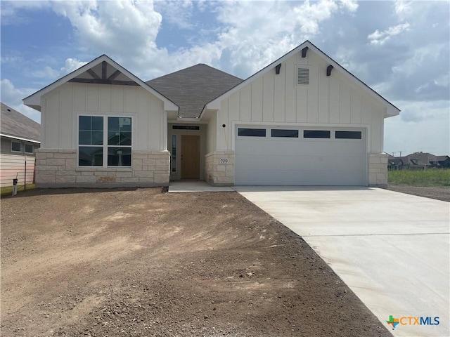 709 Killam Dr, Temple, TX 76502 - view of front of house featuring board and batten siding, an attached garage, driveway, and stone siding