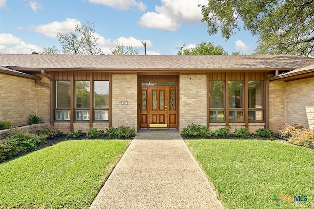517 Cherokee Dr, Temple, TX 76504 - doorway to property featuring brick siding, a lawn, and board and batten siding