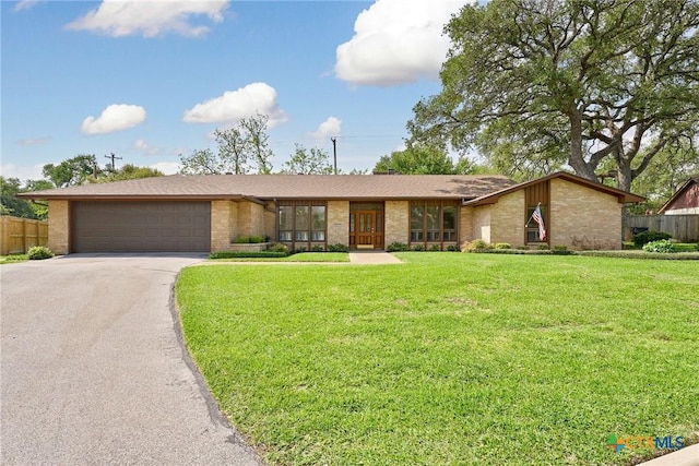 517 Cherokee Dr, Temple, TX 76504 - ranch-style home featuring an attached garage, fence, aphalt driveway, and brick siding