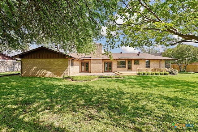 517 Cherokee Dr, Temple, TX 76504 - back of house featuring a patio area, a lawn, a chimney, fence, and brick siding