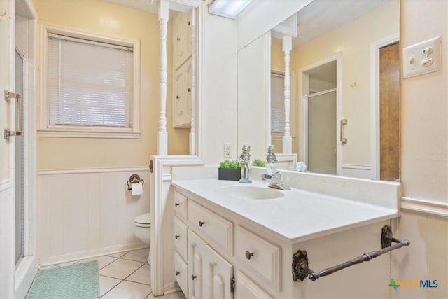 bathroom featuring an enclosed shower, vanity, tile patterned floors, and toilet