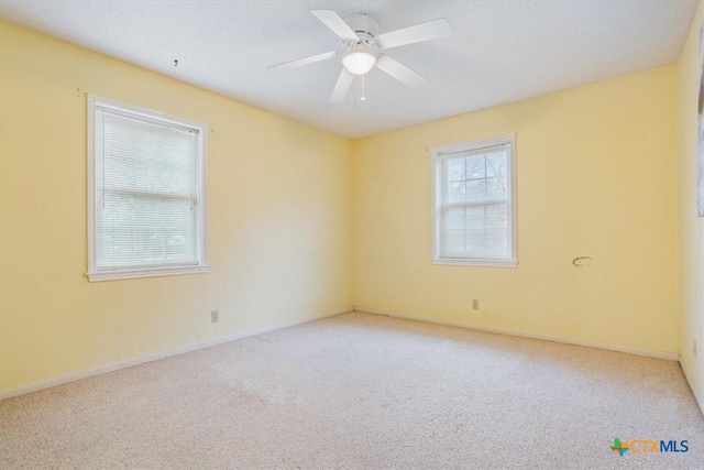 carpeted spare room with ceiling fan