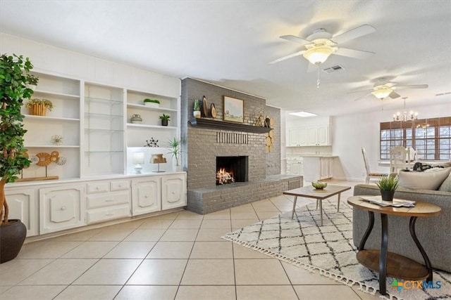 tiled living room featuring built in shelves, a fireplace, and ceiling fan with notable chandelier