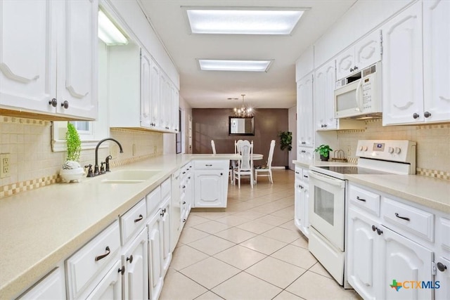 kitchen featuring pendant lighting, sink, white appliances, light tile patterned floors, and white cabinetry