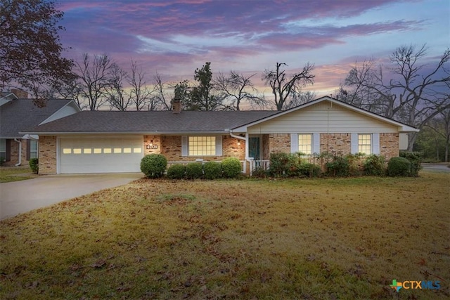 ranch-style home featuring a yard and a garage