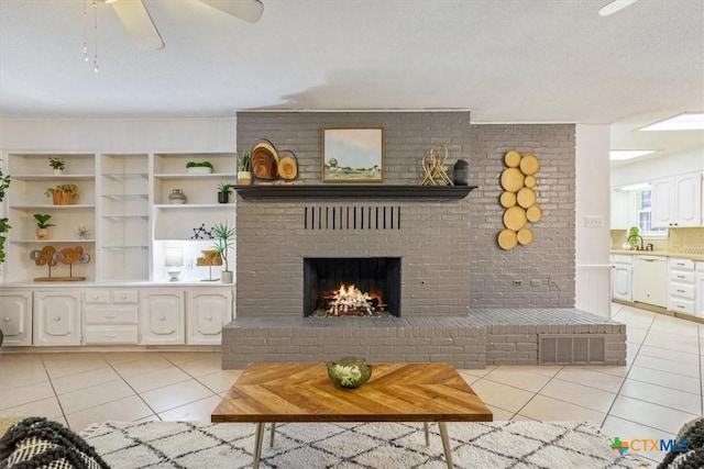 unfurnished living room featuring light tile patterned flooring, sink, a brick fireplace, and a textured ceiling