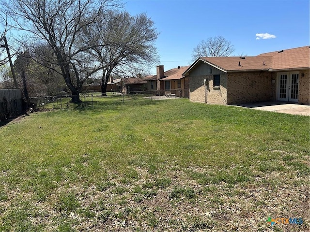 view of yard with a patio area, french doors, and a fenced backyard