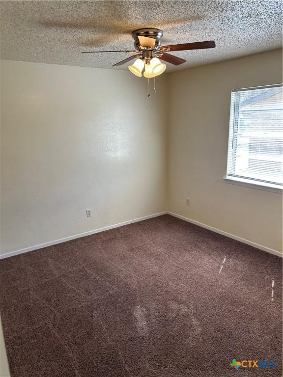 unfurnished room featuring baseboards, a textured ceiling, ceiling fan, and carpet flooring