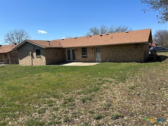 back of property featuring a patio area, french doors, a yard, and fence