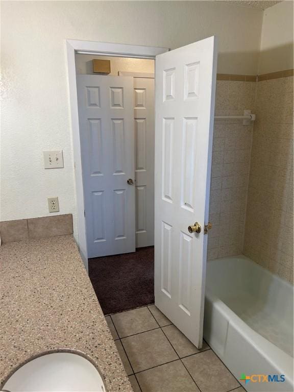 full bath with tile patterned floors, shower / bathtub combination, and a sink