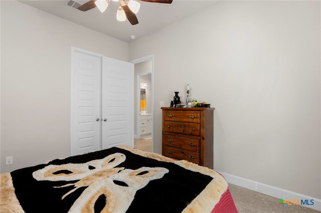 bedroom with ceiling fan, light colored carpet, and a closet