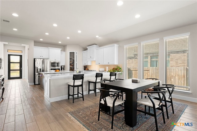 dining area with light wood-type flooring and a wealth of natural light