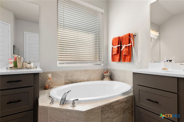 bathroom featuring vanity and a relaxing tiled tub