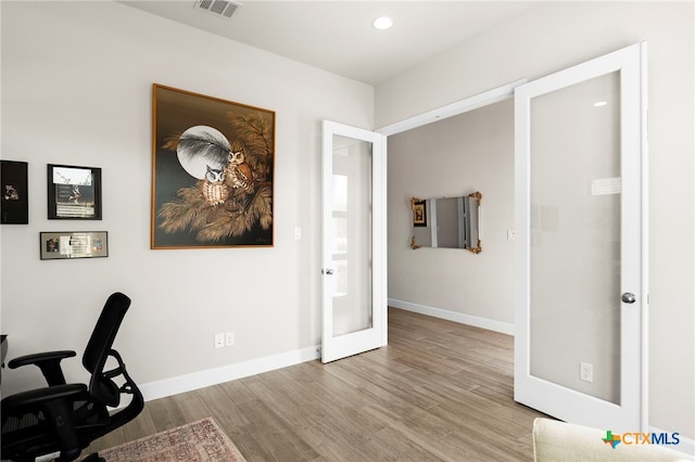 unfurnished office featuring light wood-type flooring and french doors